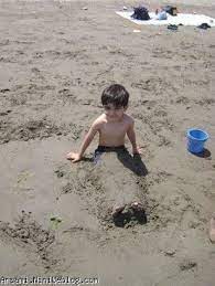 کودک در حال شن بازی در ساحل قشم