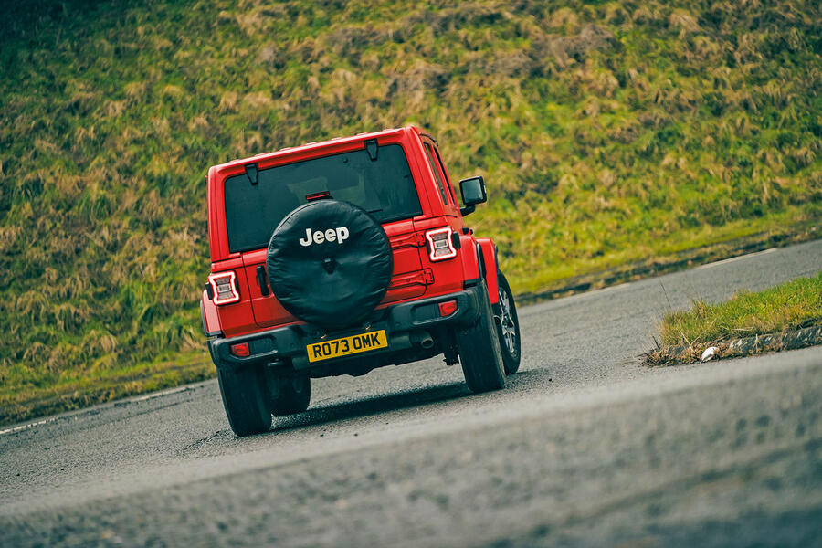 نمای جانبی جیپ رنگلر صحرا در آفرود جیپ رنگلر صحرا قرمز در حال حرکت در جاده خاکی