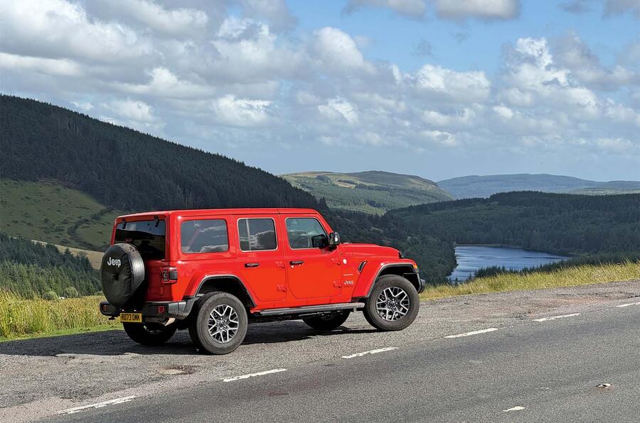 رنگلر مثل یک سگ بزرگ قرمز خوشحال جیپ رنگلر قرمز در جاده باریک روستایی