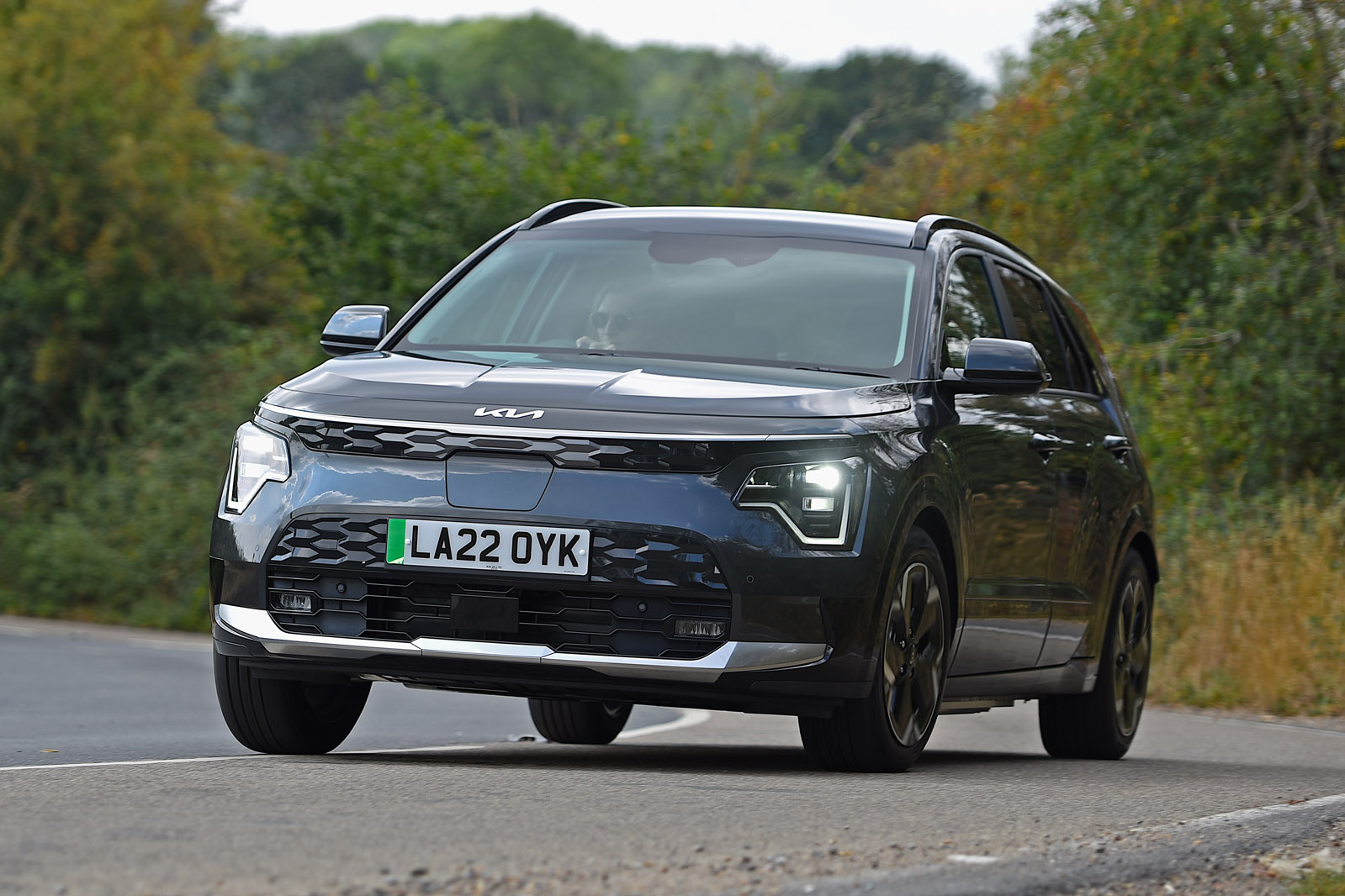 نمای جانبی کیا نیرو EV 2025 در حال حرکت در جاده