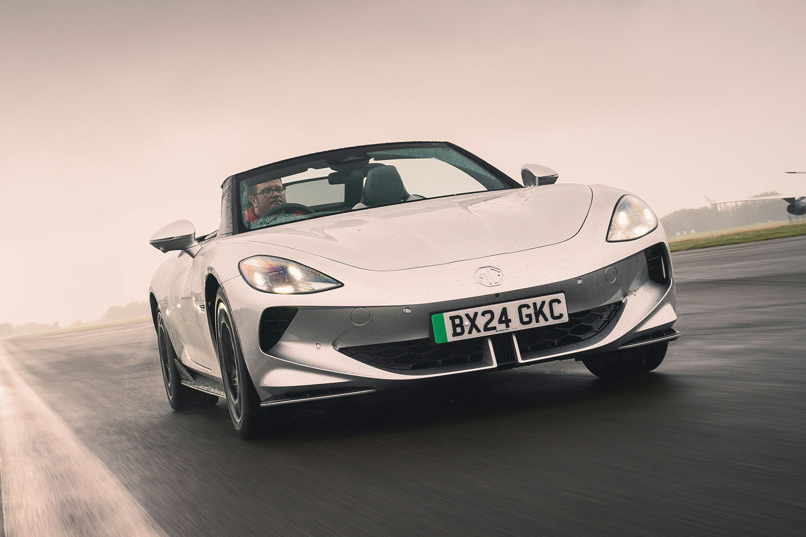 ام جی سایبرستر ۲۰۲۵ در جاده با درهای قیچی شکل باز نمای جلو ام جی سایبرستر در حال حرکت با سقف باز