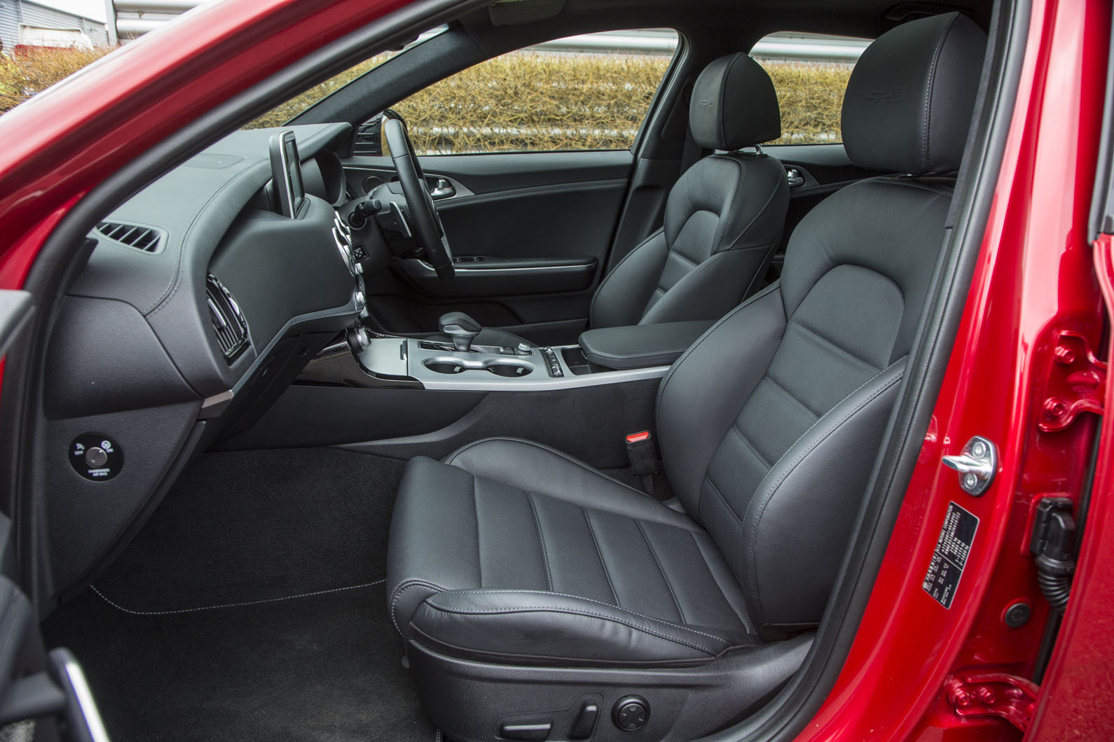 نمای داخلی کابین کیا استینگر با تمرکز بر داشبورد و صندلی‌ها