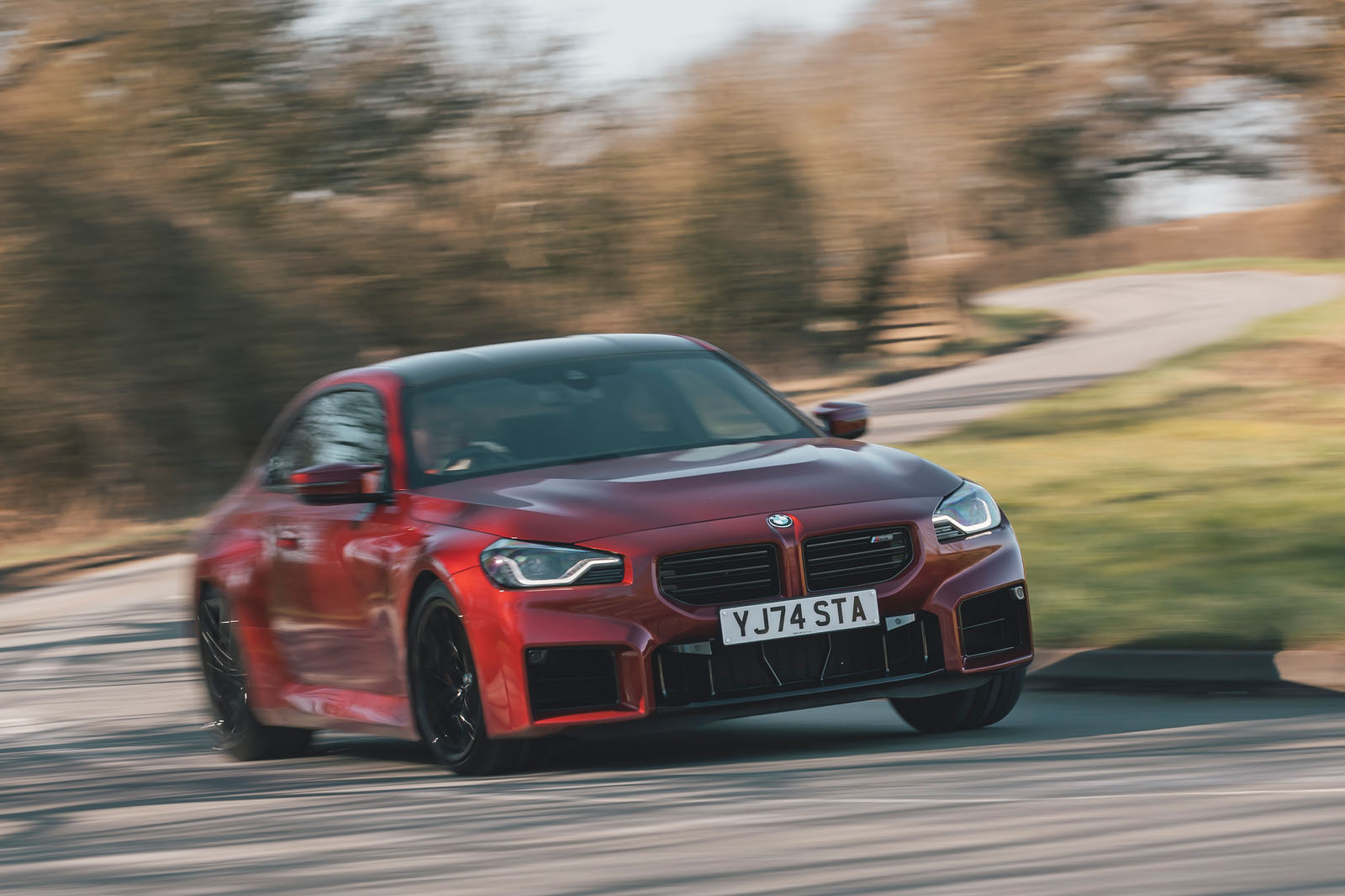 نمای جلو و گوشه BMW M2 در حال حرکت با بلور پس‌زمینه